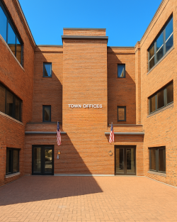 Brick building with a central entrance, name displayed in white letters, and two American flags.